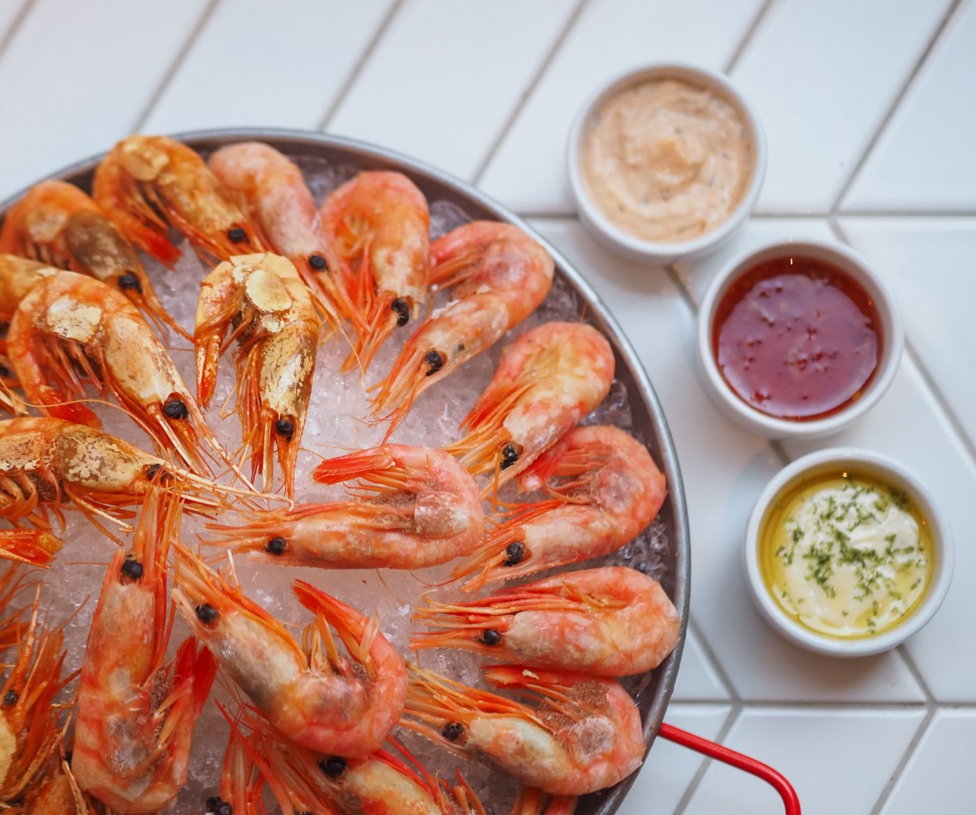 Camarones frescos sobre hielo con salsas