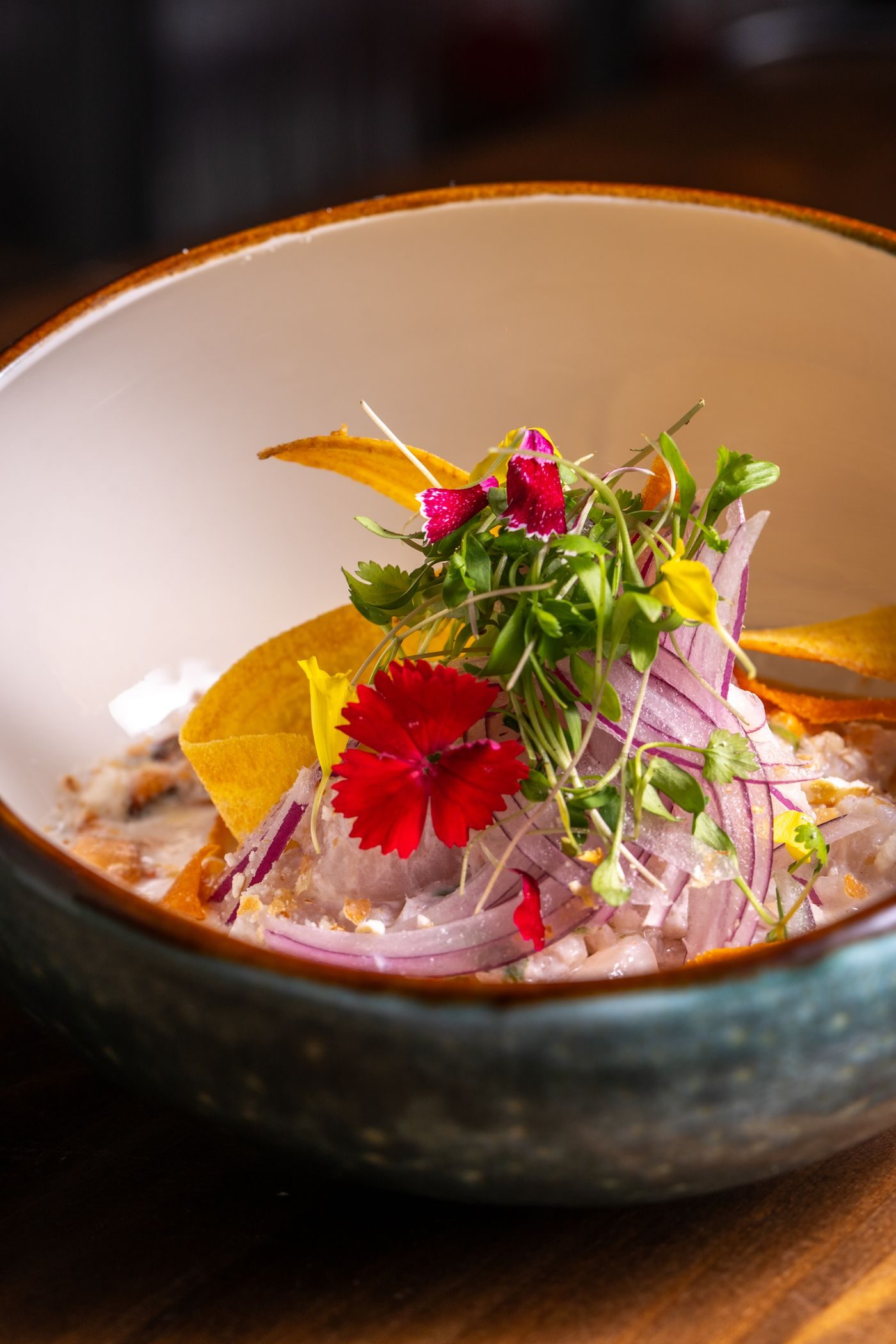 Ceviche de pescado con cebolla morada y flores comestibles